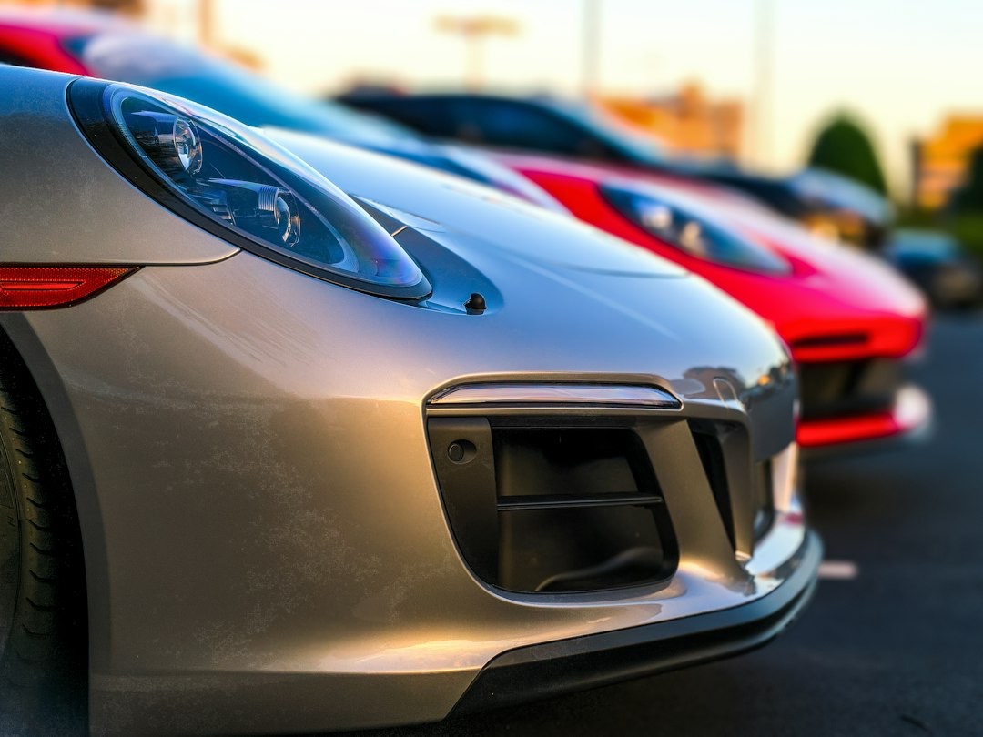 Silver sports car parked in a row with other cars.